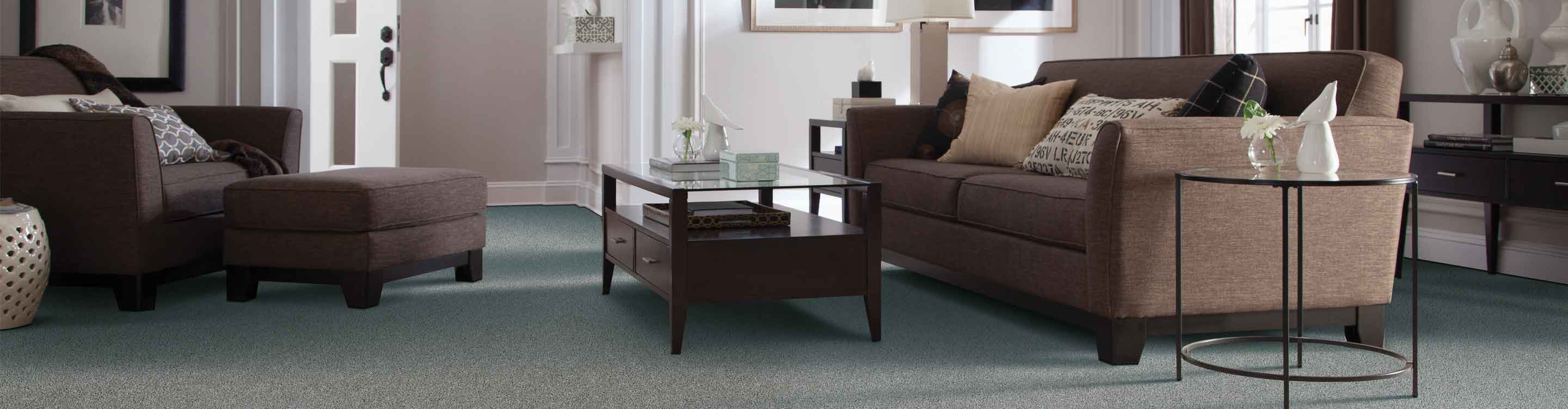 Living room with brown couch and two chairs, beige carpet